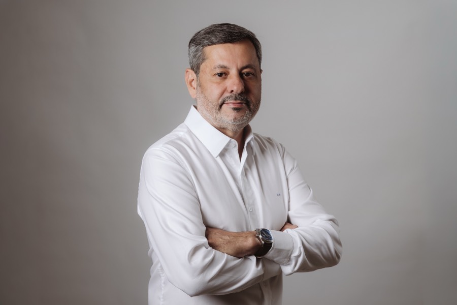Rogerinho, de braços cruzados, camisa branca